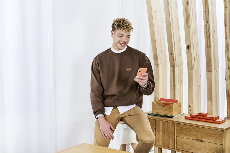 Mann auf Hocker mit Handy